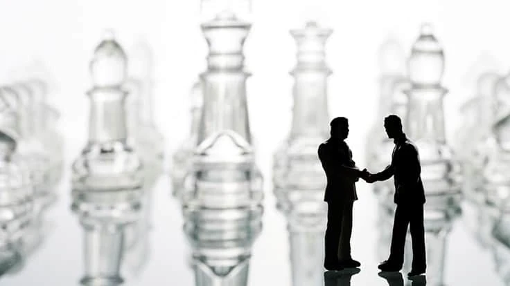 chess pieces figures shaking hands