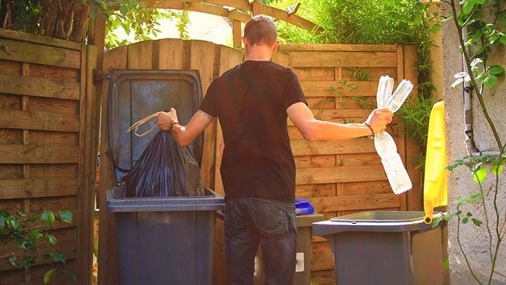 man throwing out garbage and sorting recyclables