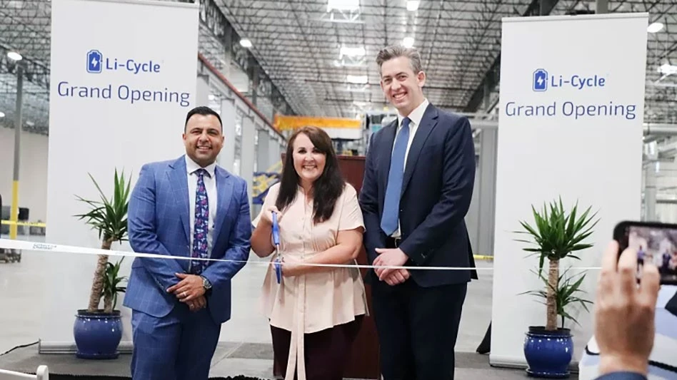 a man, woman and another man cut a ribbon