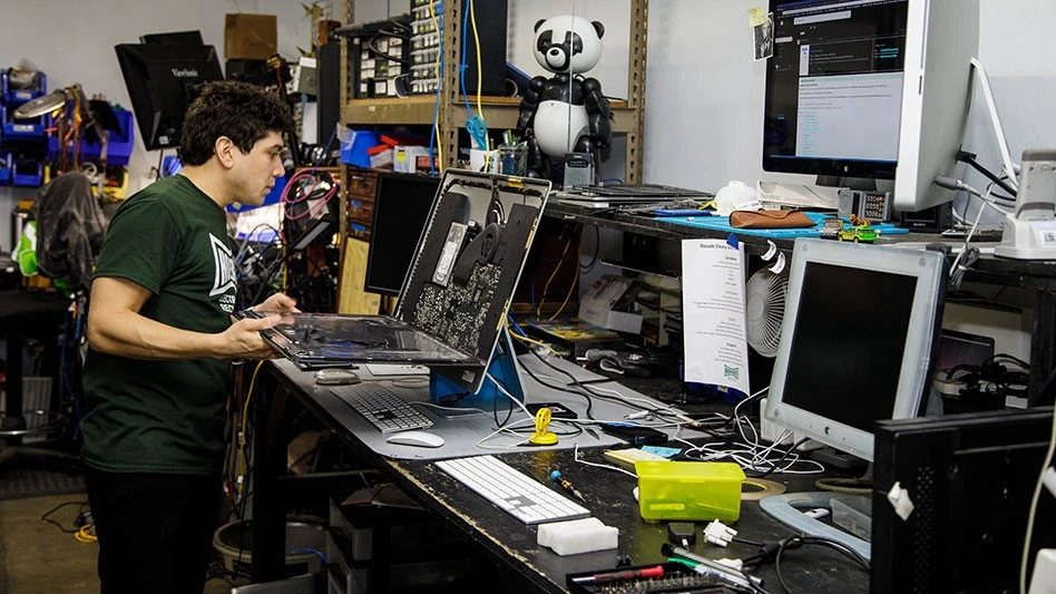 a man tests a dismantled computer