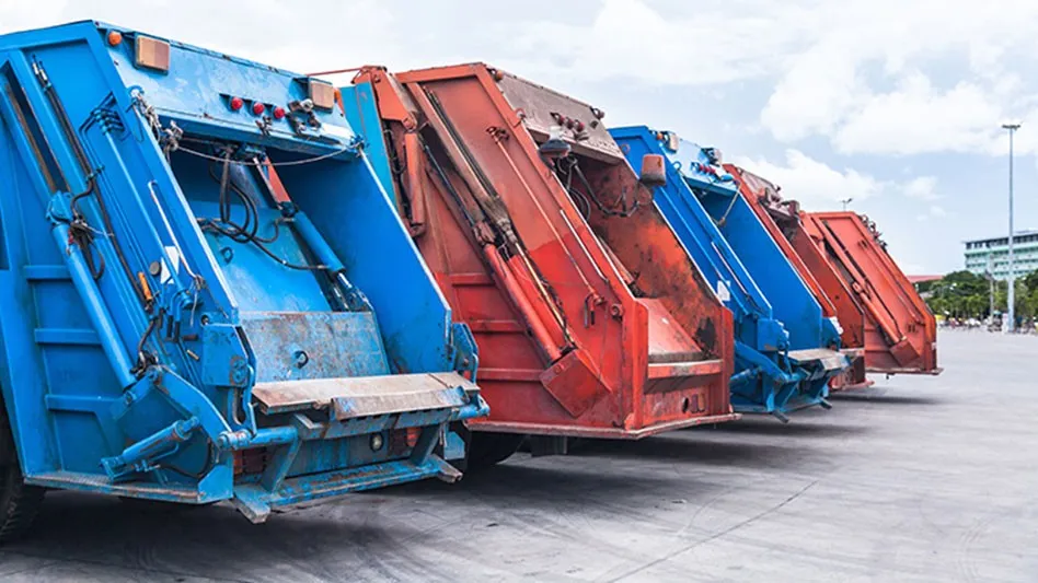 row of the back of three rear-loader refuse collection trucks