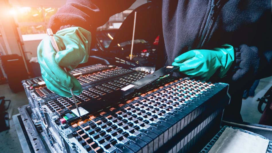 a person wearing blue rubber gloves working on an EV battery