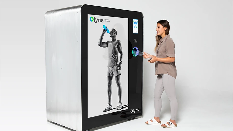 A woman inserts a plastic bottle in to an Olyns Cube reverse vending machine.