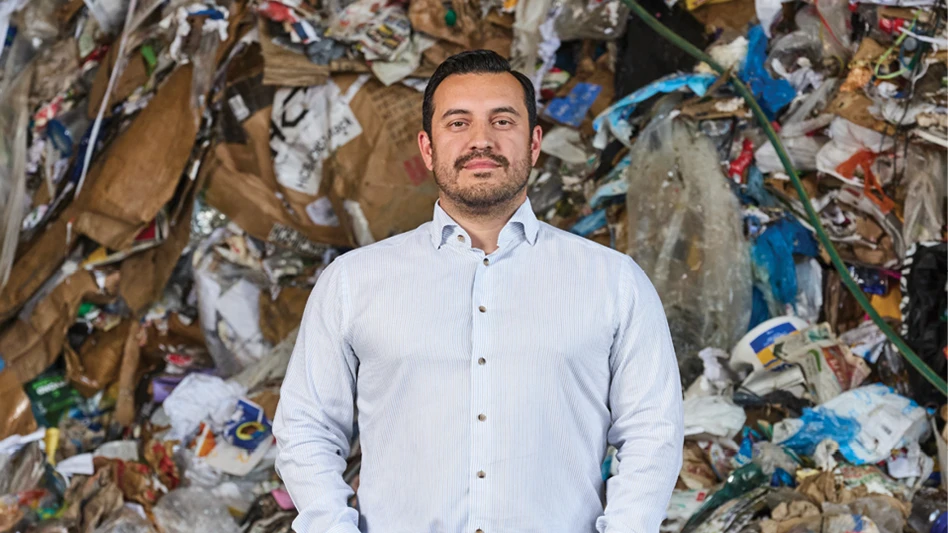 GFL Environmental President of Recycling Stephen Miranda stands in front of a tall pile of scrap.