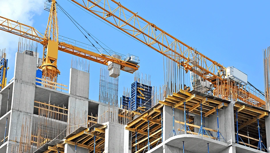 Crane and building construction site against blue sky