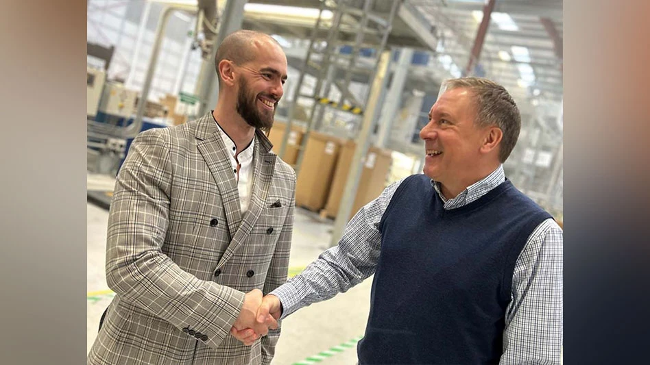 two men shake hands in a warehouse