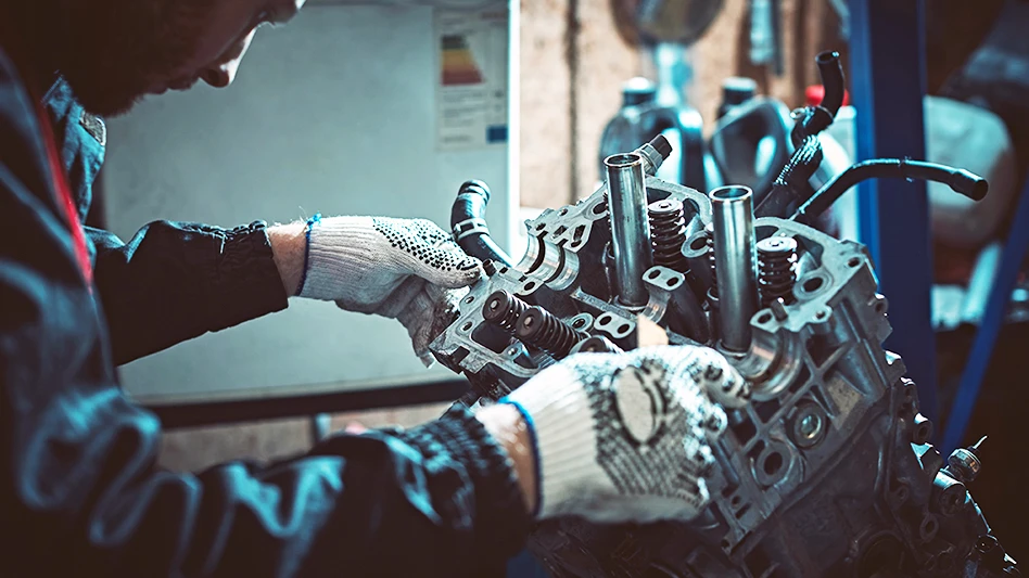 man with gloves attends an engine