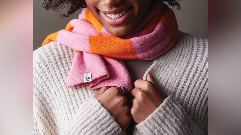 A woman pulling on a scarf.