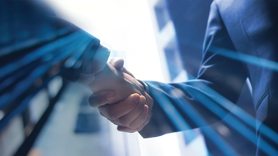 Two businessmen shake hands as light pours in from outside