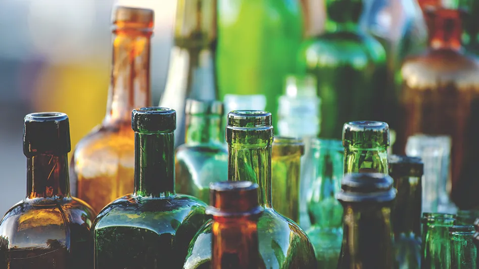 A lineup of glass bottles of various shapes, sizes and colors.