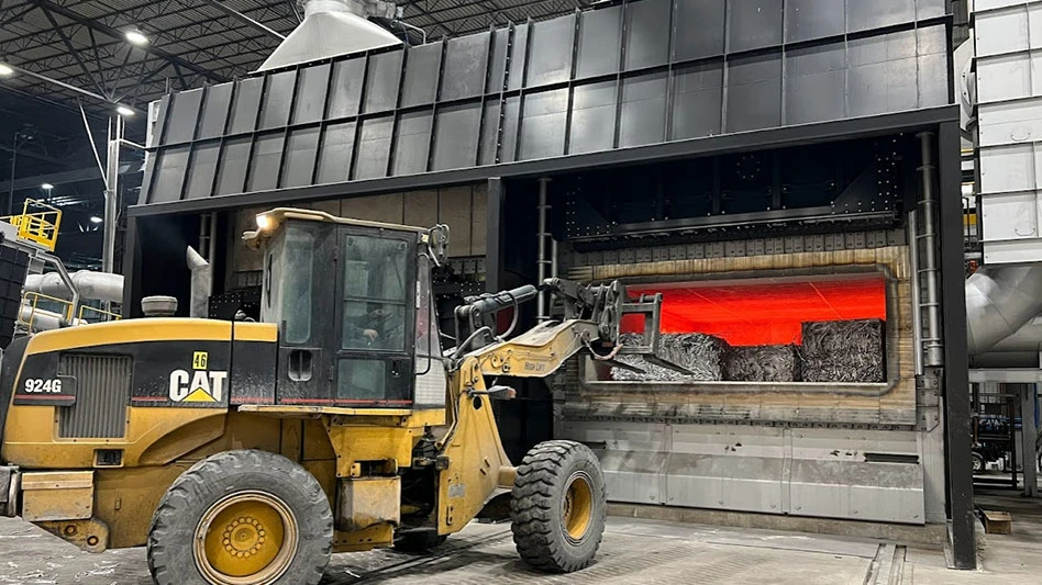 a wheel loader feeds bales of scrap into an aluminum furnace