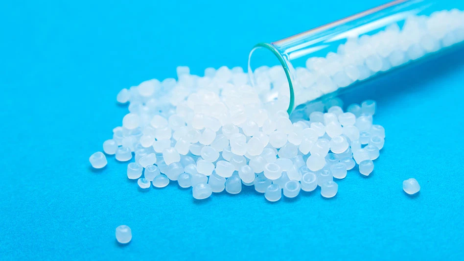 a test tube of translucent plastic pellets on an acqua blue background