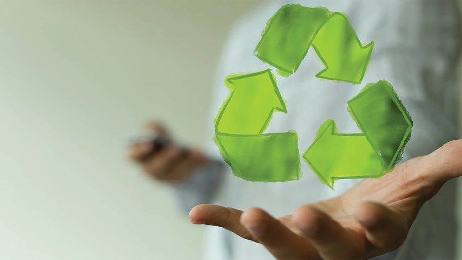 A hand holding up the green arrow recycling symbol.