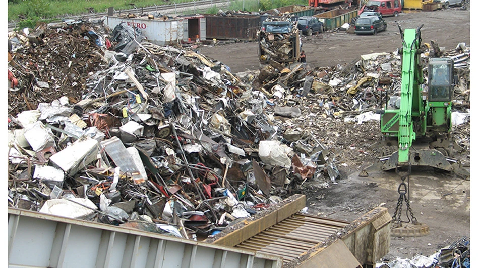 a sennebogen material handler stands ready to feed a conveyor that leads to an auto shredder