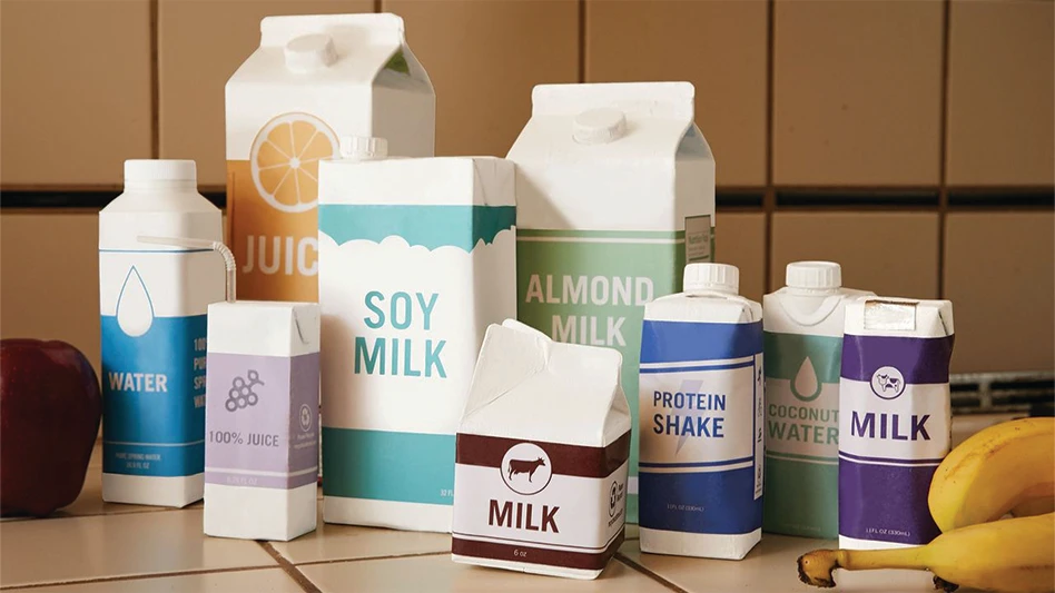 A number of various sizes of beverage cartons on top of a table.