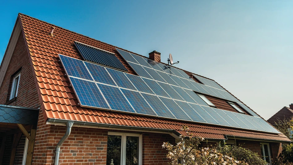 Solar panels installed on the red-colored roof of a house.