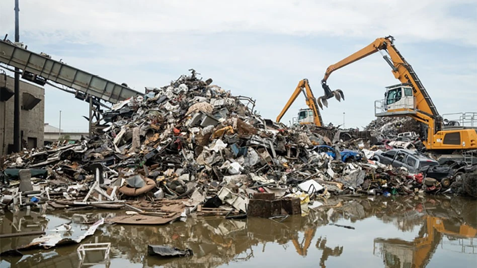 pile of scrap metal near a conveyor with yellow machines