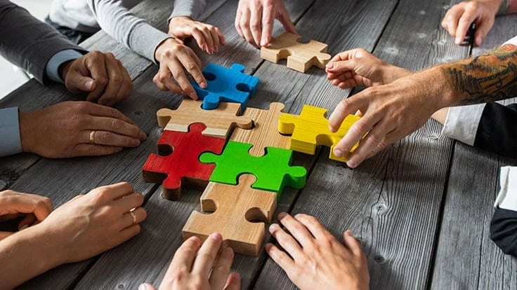 people assembling puzzle